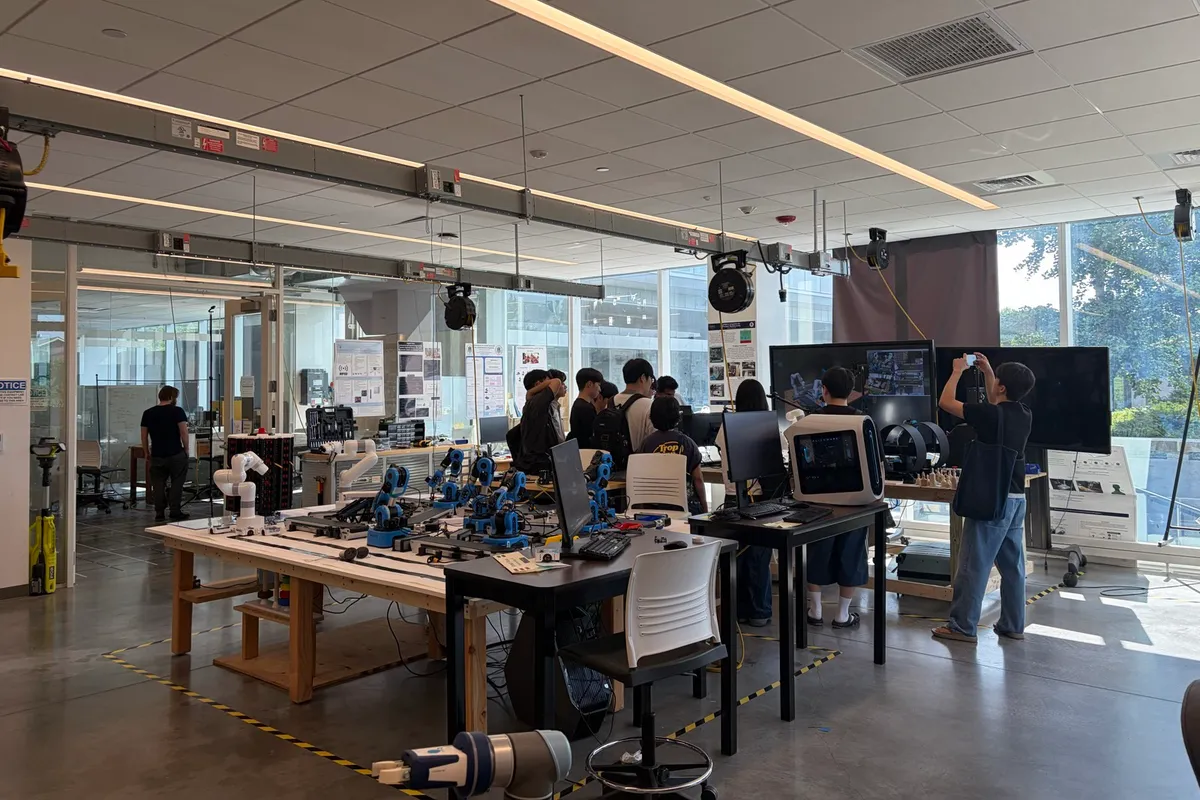 Students gathered around testbed equipment during a demo day in the capstone room