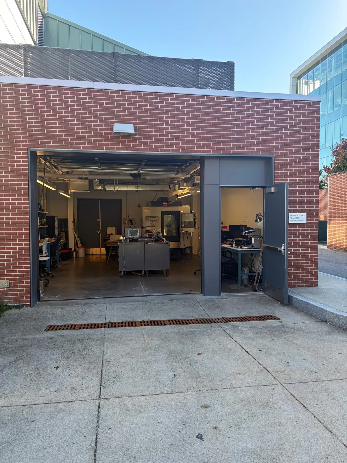 Open garage door of the Driver and Vehicle Tracking Research Laboratory, showing a CNC machine and workbenches inside